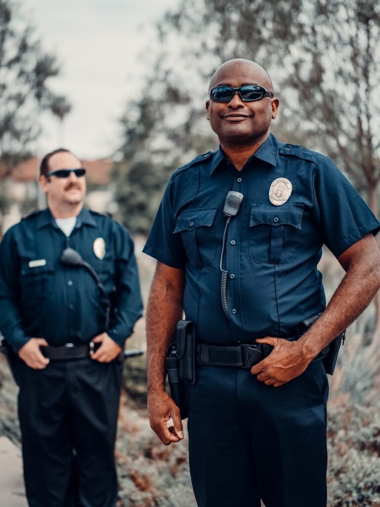 Two police officers in uniform standing outdoors, ensuring public safety.